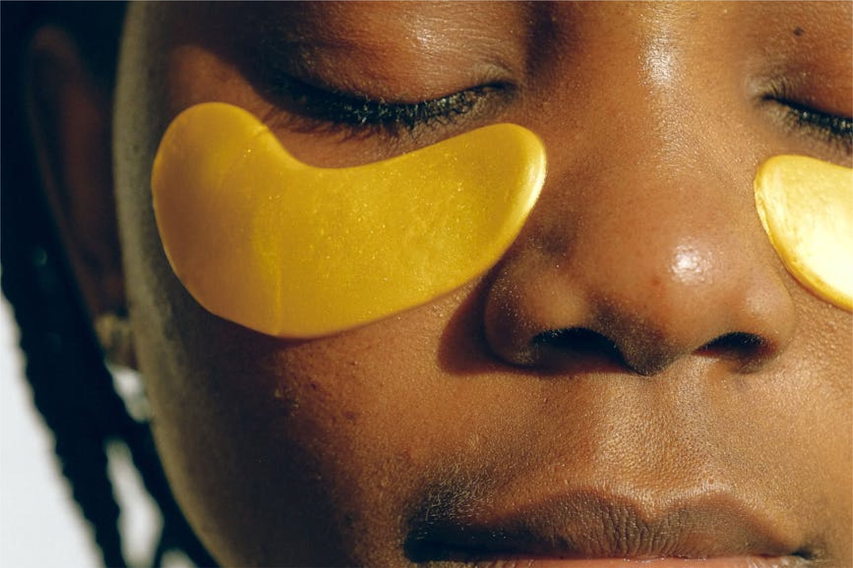 Person with golden eye patches relaxing